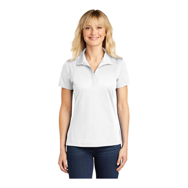 A woman wearing a white Sport-Tek polo shirt.