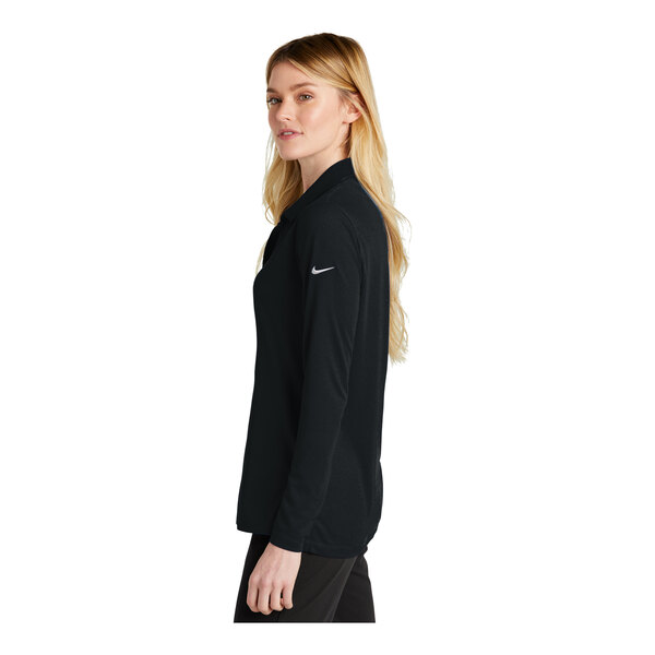 A woman wearing a black Nike long sleeve polo.