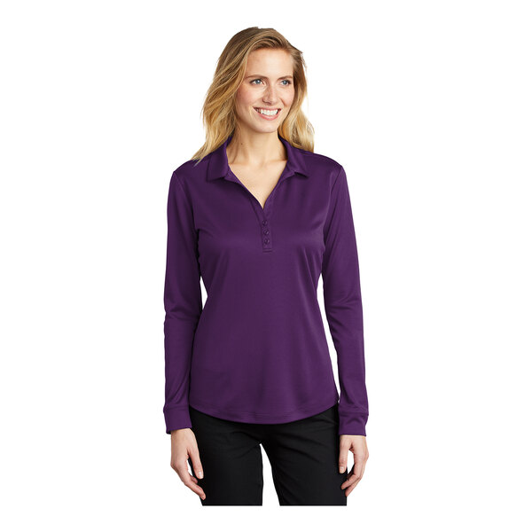 A woman wearing a Port Authority bright purple long sleeve polo shirt.