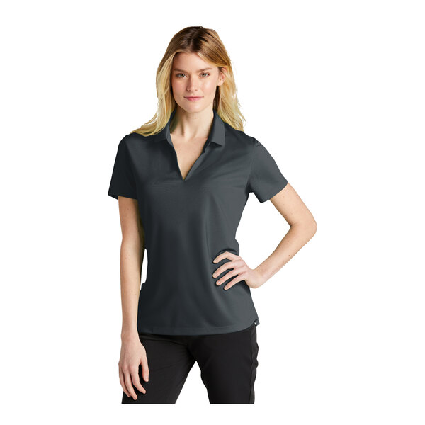 A woman wearing a grey Nike polo shirt with black trim.