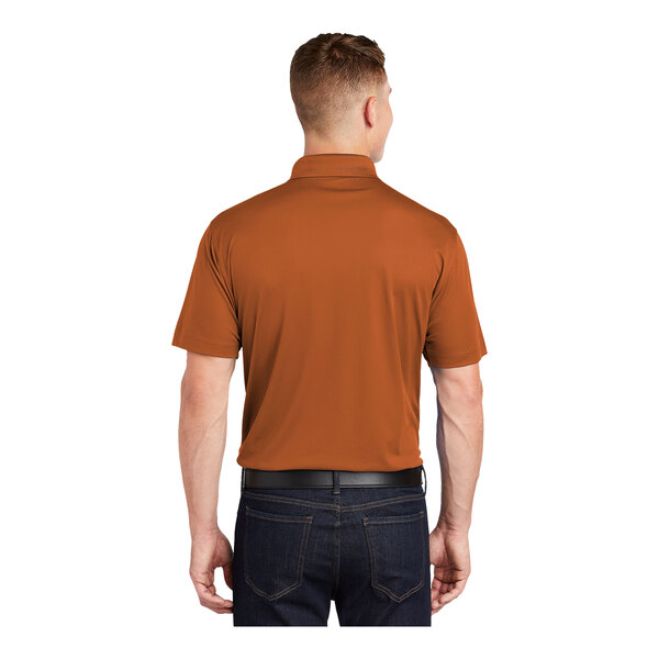 A man wearing a Texas orange Sport-Tek polo shirt.