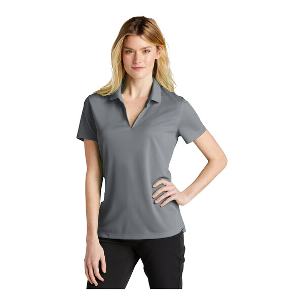 A woman wearing a grey Nike short sleeve polo shirt.