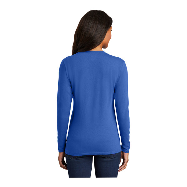 A woman wearing a Port & Company women's royal blue long sleeve T-shirt.