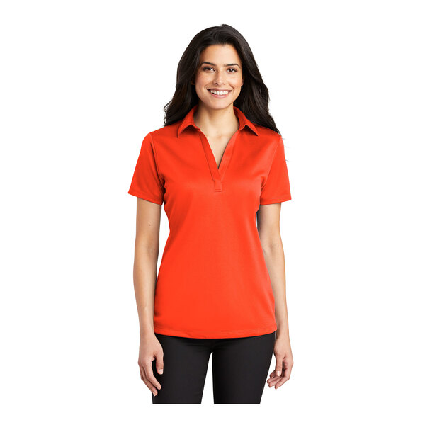 A woman wearing a Port Authority neon orange polo shirt.