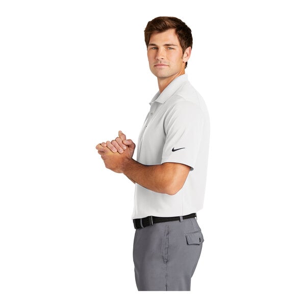 A man wearing a white Nike Dri-Fit polo.