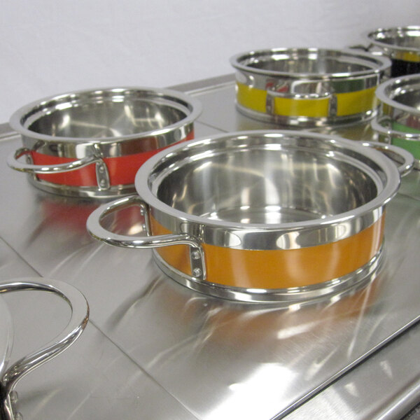 A Bon Chef orange steam table pot on a stainless steel surface.