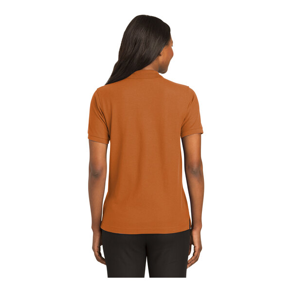 A woman wearing a Port Authority Texas Orange polo shirt.