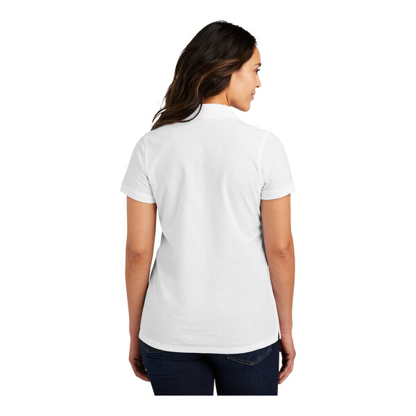 A woman wearing a white Port Authority polo shirt with a white collar.