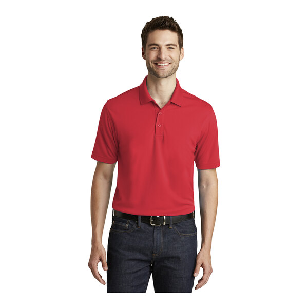 A man wearing a rich red Port Authority Dry Zone short sleeve polo shirt.