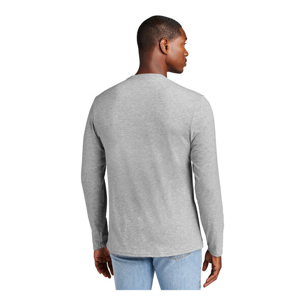 A man wearing a District light heather grey long sleeve t-shirt.