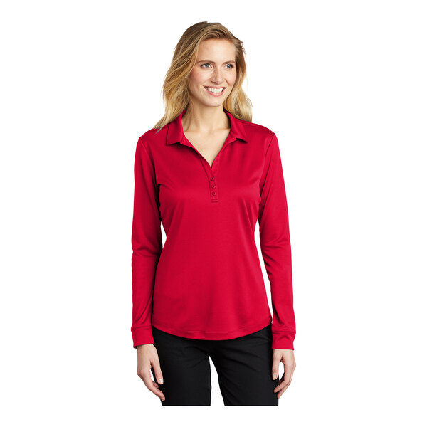 A woman wearing a red Port Authority long sleeve polo shirt.