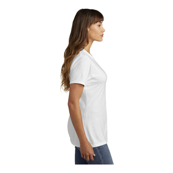 A woman wearing a white Port & Company T-shirt.