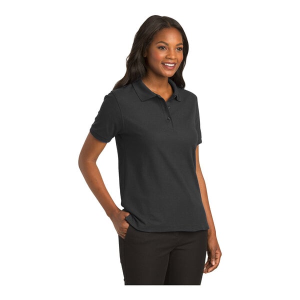 A woman wearing a black Port Authority polo shirt.