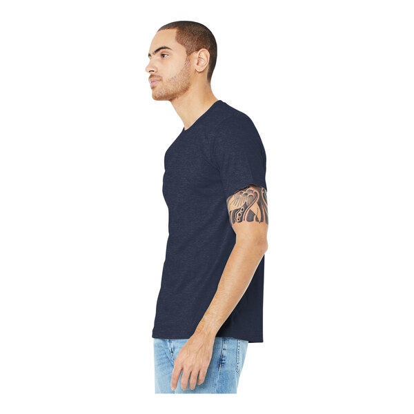 A man with a tattoo on his arm wearing a Bella + Canvas heather midnight navy t-shirt.