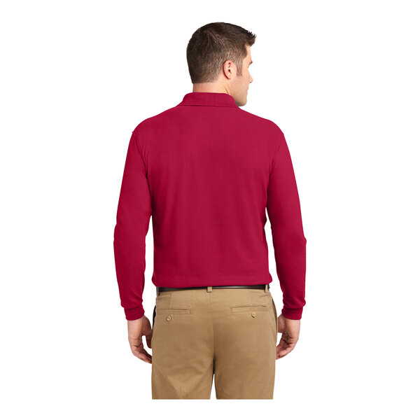 A man wearing a red Port Authority® long sleeved polo shirt.