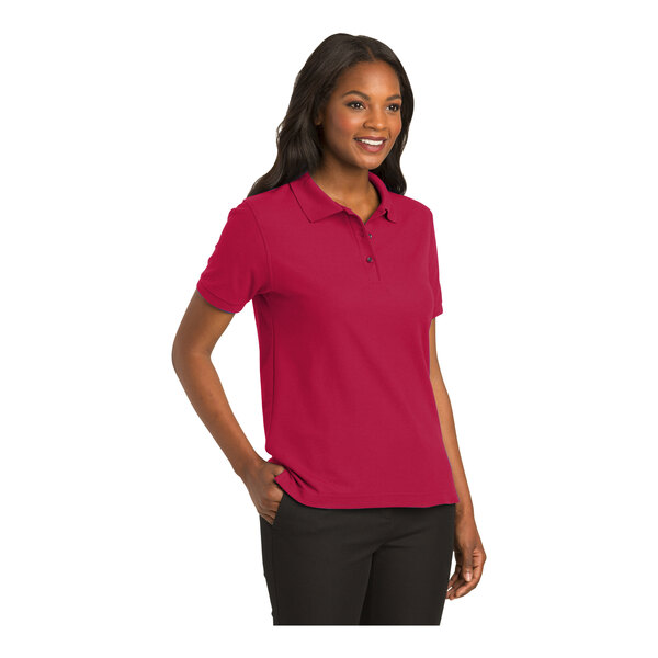 A woman wearing a red Port Authority silk touch polo shirt.