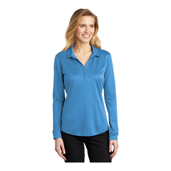 A woman wearing a Port Authority Carolina blue long sleeve polo shirt.