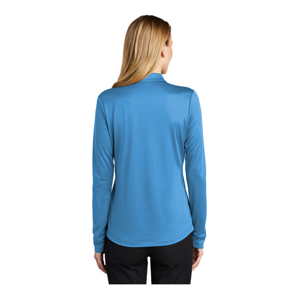 A woman wearing a Port Authority Carolina Blue long sleeve polo shirt.