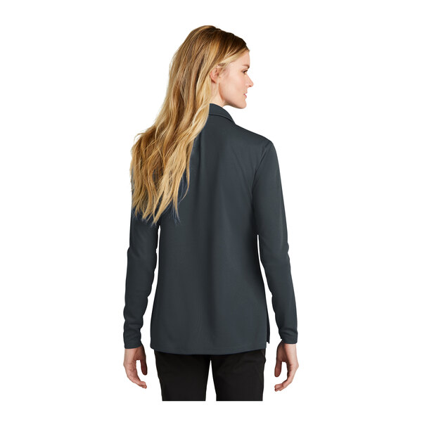 A woman with long blonde hair wearing an anthracite Nike long sleeve polo.