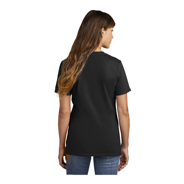 A woman wearing a black Port & Company short sleeve t-shirt.