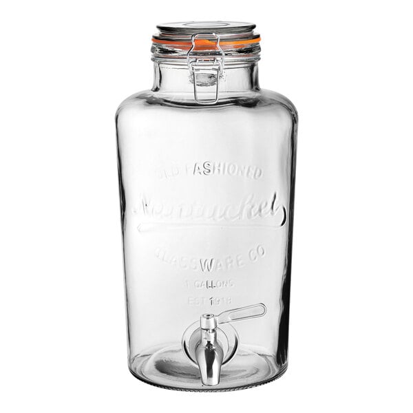 A clear glass jar with a spigot and a handle.