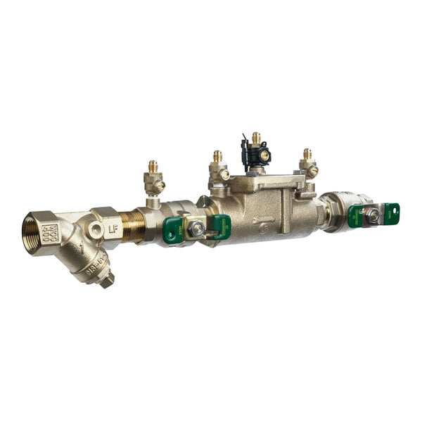 A Watts double check valve assembly with a brass body and two green handles.