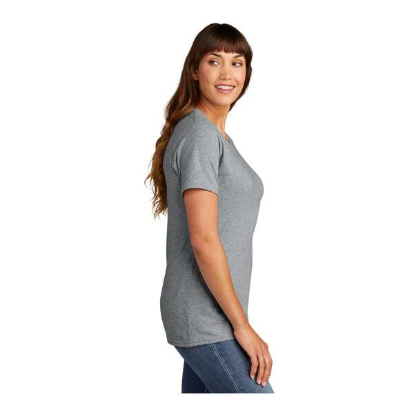 A woman wearing an Athletic Heather Port & Company T-shirt.