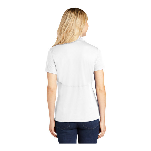 A woman wearing a white Sport-Tek polo shirt.