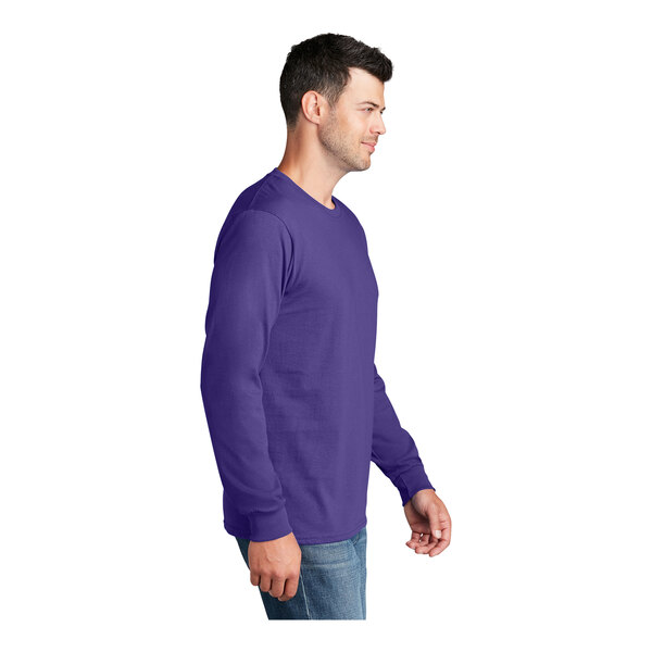 A man wearing a Port & Company purple long sleeve t-shirt.