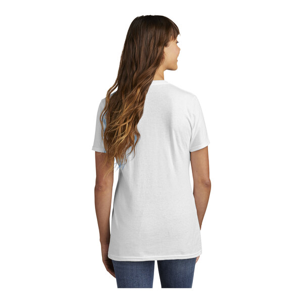 A woman with long hair in a white Port & Company short sleeve t-shirt.