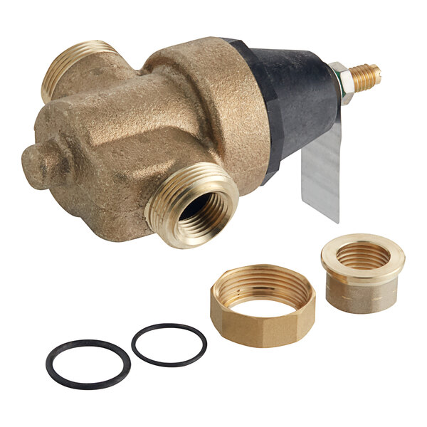 A Watts brass water pressure reducing valve with brass fittings on a black pipe.