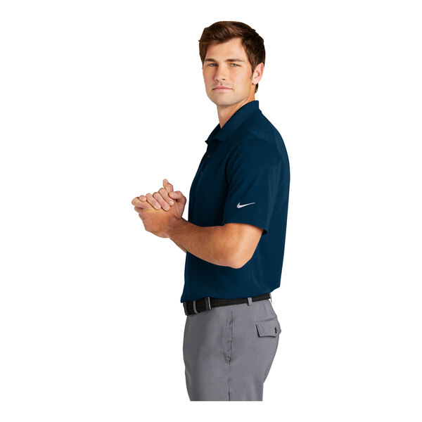 A man wearing a navy Nike Dri-Fit polo shirt.