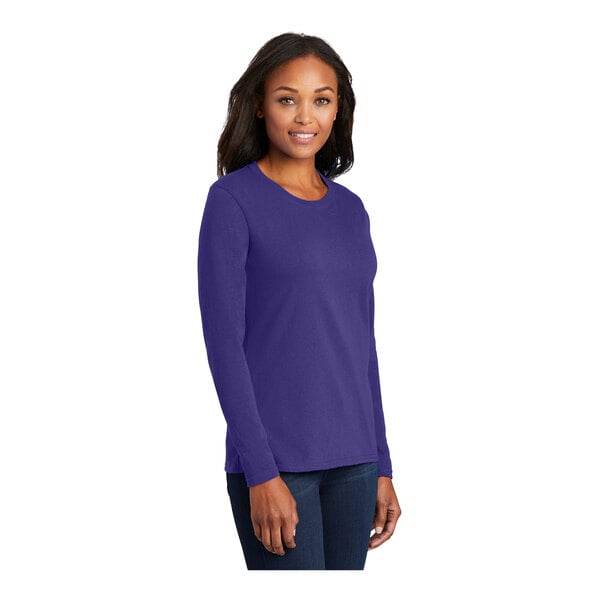 A woman wearing a purple Port & Company long sleeve t-shirt.