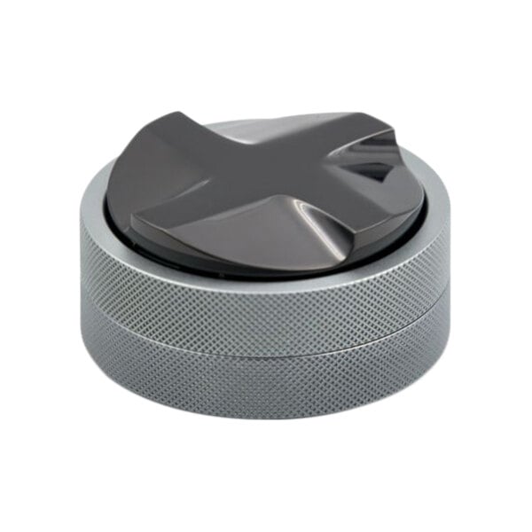 A grey titanium coffee distributor with a black cross.