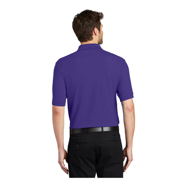 A man wearing a Port Authority purple silk touch polo shirt.