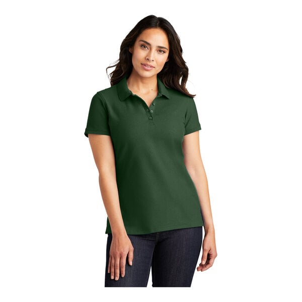 A woman wearing a Port Authority deep forest green polo shirt.