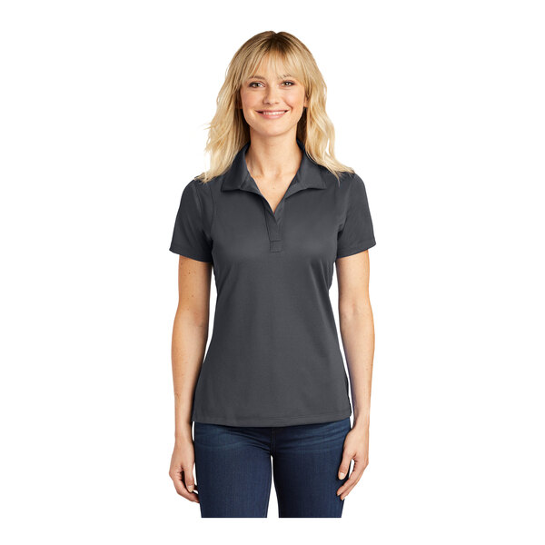 A woman wearing a grey Sport-Tek short sleeve performance polo shirt.