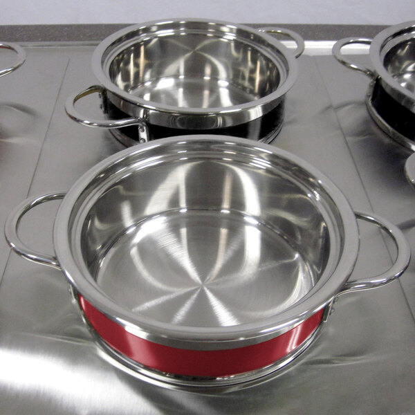 A Bon Chef stainless steel steam table pot with red handles.