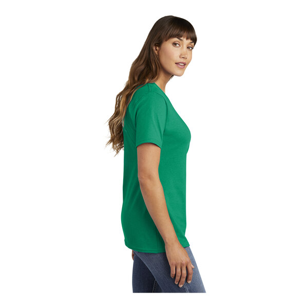 A woman wearing a green Port & Company short sleeve T-shirt with a v-neck.