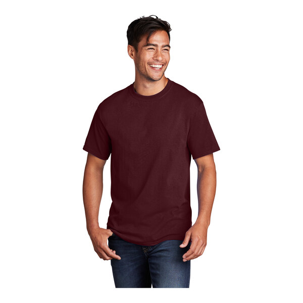 A man wearing a Port & Company athletic maroon short sleeve t-shirt.