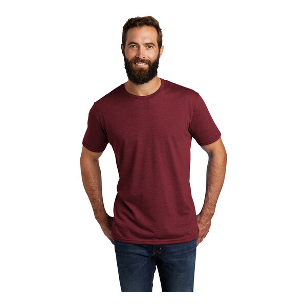 A man with a beard wearing a red AllMade short sleeve t-shirt.