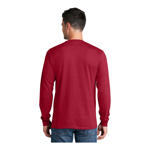 A man wearing a red Port & Company long sleeve shirt.