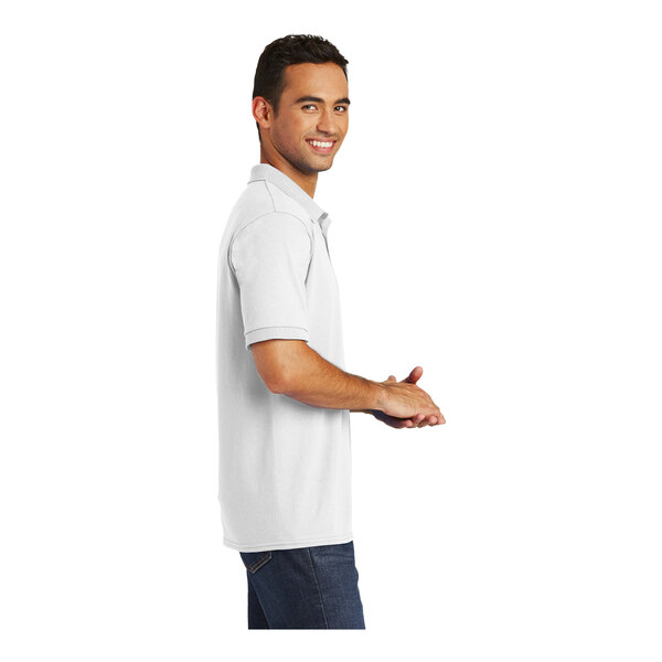 A man wearing a white Port & Company short sleeve jersey polo.