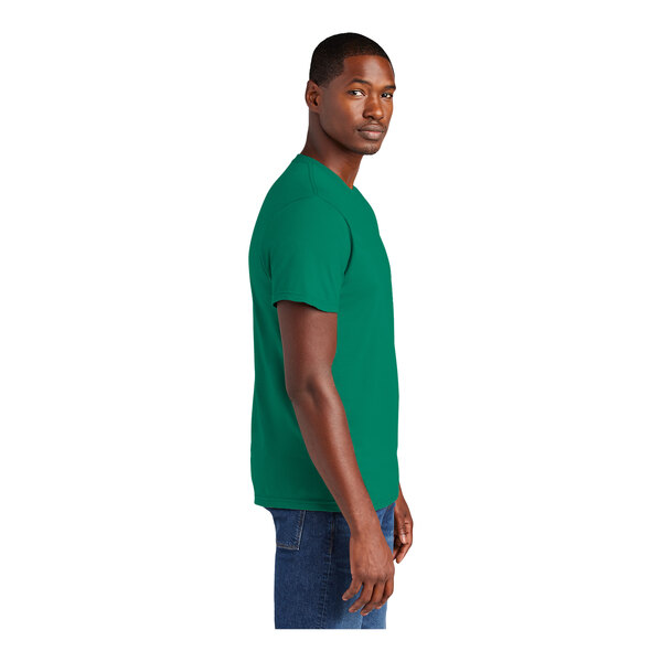 A person wearing a District Unisex Jewel Green short sleeve t-shirt.