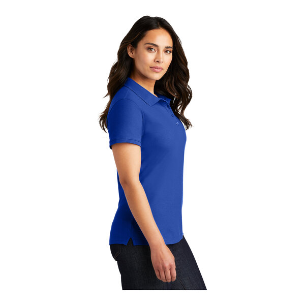 A woman wearing a blue Port Authority polo shirt with a white collar.