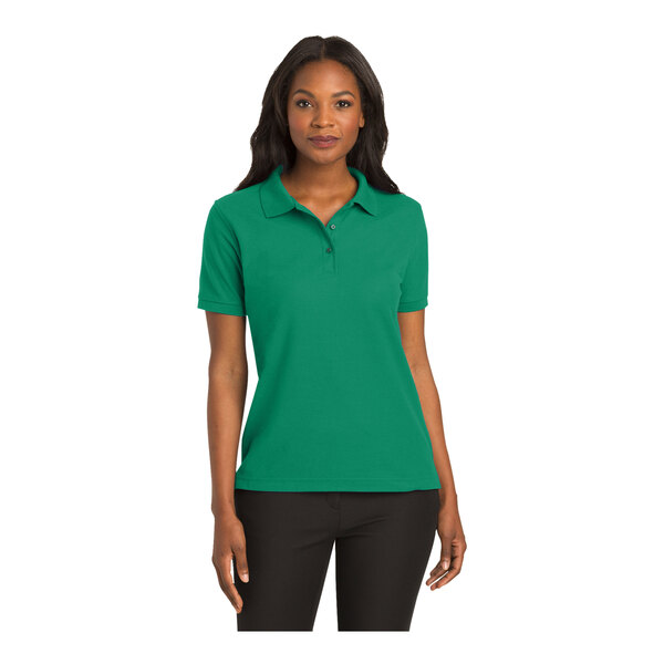 A woman wearing a Port Authority Kelly green polo shirt.