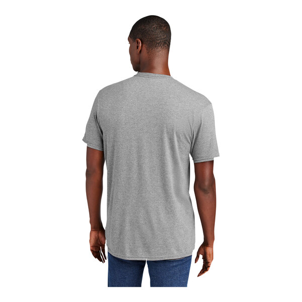 A man wearing a light heather grey District t-shirt.