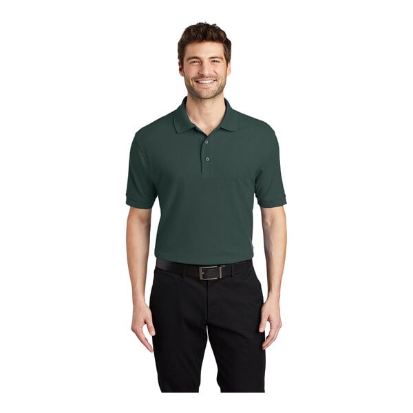 A man wearing a dark green Port Authority Silk Touch Pique Polo shirt.