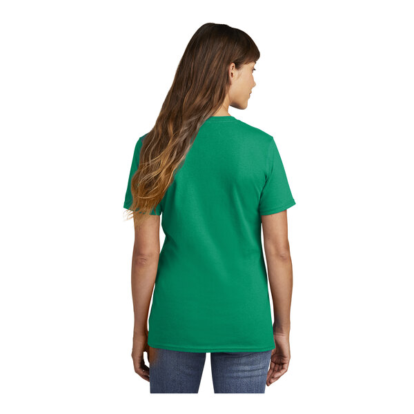A woman wearing a green Port & Company short sleeve T-shirt.