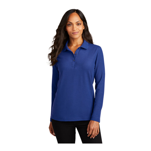 A woman wearing a Port Authority royal blue long sleeve polo shirt.